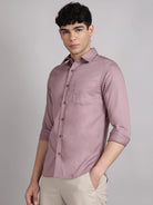 Man wearing a peach satin shirt against a gray background