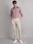 Man wearing a shirt, beige pants, and white sneakers on a gray background