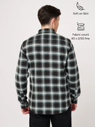 Man wearing a black and green plaid shirt