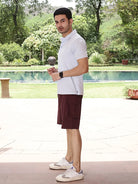 Man wearing a light sky blue polo shirt and maroon shorts