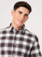 Man wearing a stylish oxford cotton bold maroon check shirt against a plain background