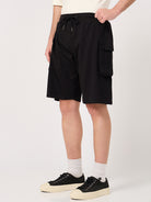 Person wearing black cargo shorts on a white background